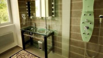 A modern bathroom with a glass shower enclosure, a glass sink, and a zebra-patterned rug.