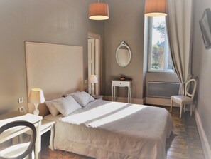 Relax in comfort with a large bed, bedside table, and chair, plus a large mirror and TV for your stay.