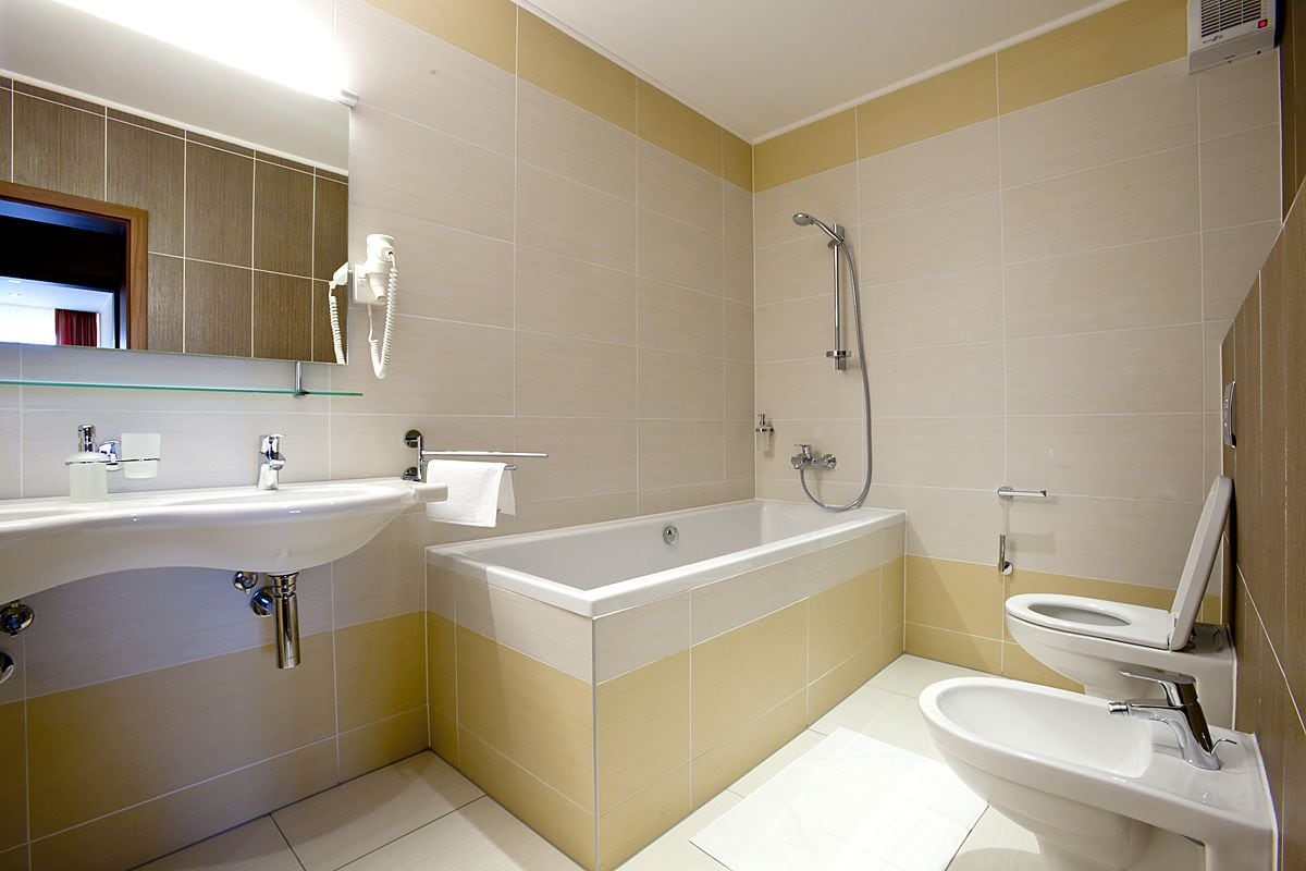 Un bagno moderno con una vasca, una doccia, un water e un lavandino.