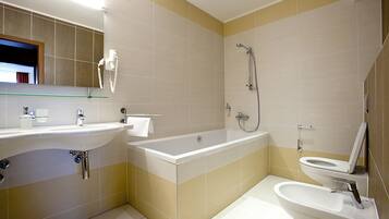 Un bagno moderno con una vasca, una doccia, un water e un lavandino.