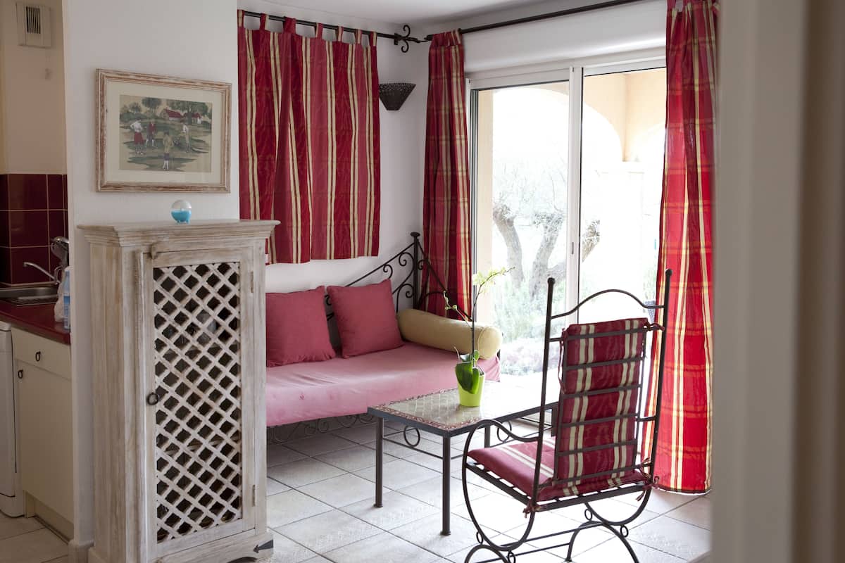 A cozy room with a sofa, a chair, a small table, and a cabinet.