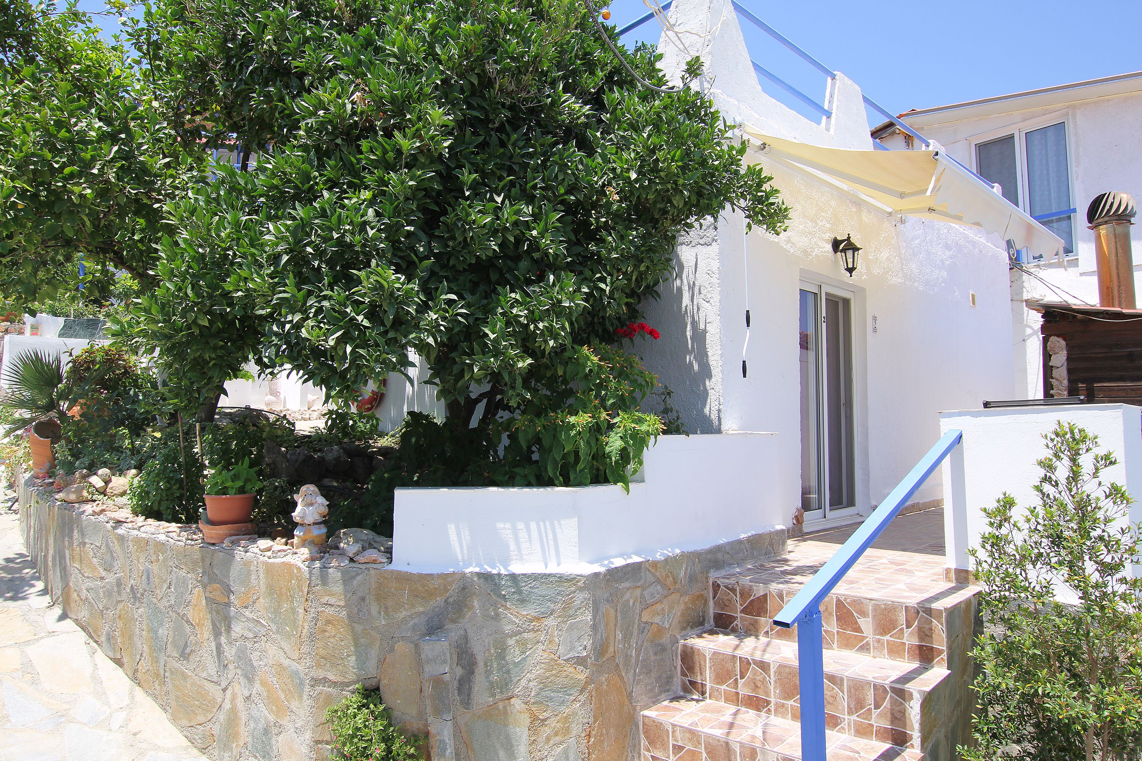 A white building with stone steps and a blue railing.