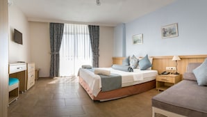 A hotel room with a bed, bedside table, lamp, and a desk with a chair. - Ponz Boutique Hotel (Kusadasi)