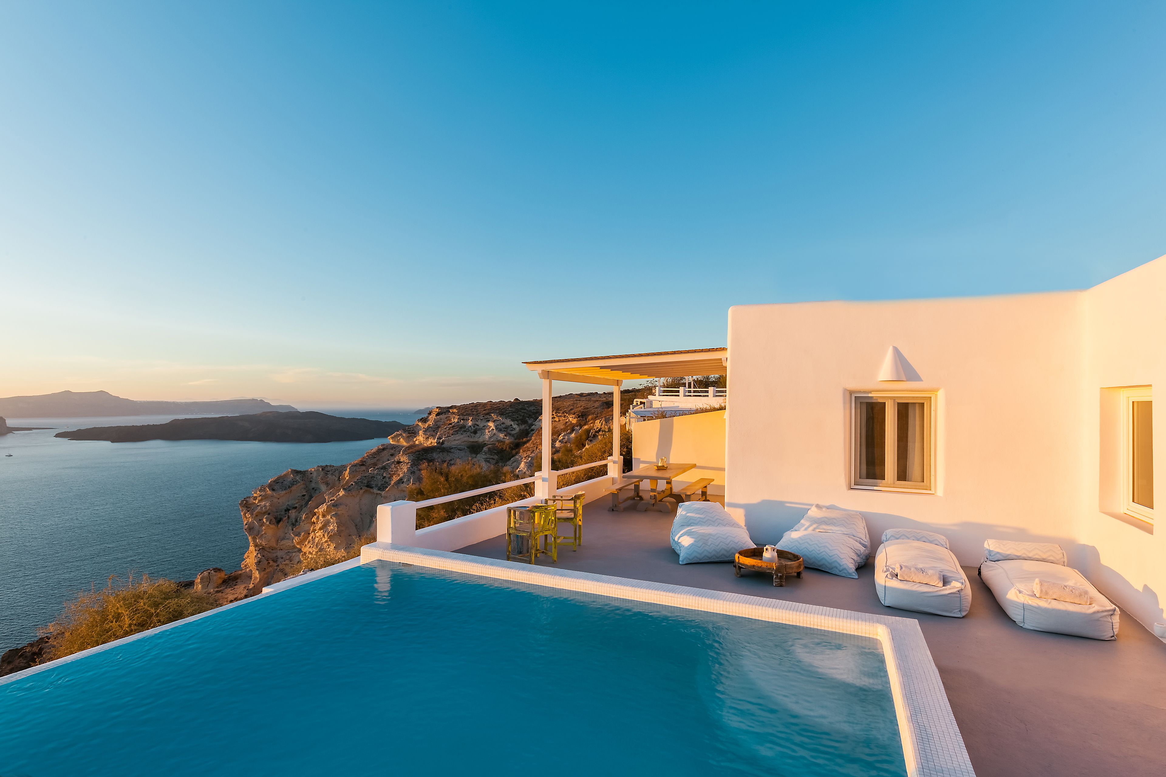 Un espace moderne aménagé au bord de la piscine, offrant une vue dégagée sur la mer et les montagnes.