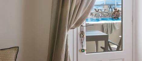 Quarto com vista para uma piscina e porta com espelho.