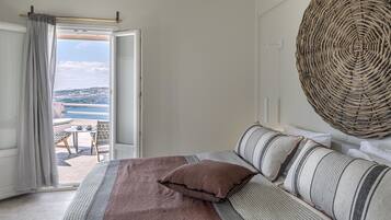 Une chambre avec un lit, une vue sur la mer et une décoration murale en osier.
