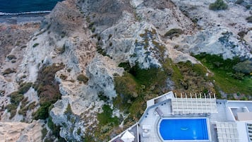 Een resort met een zwembad, terras en uitzicht op zee.