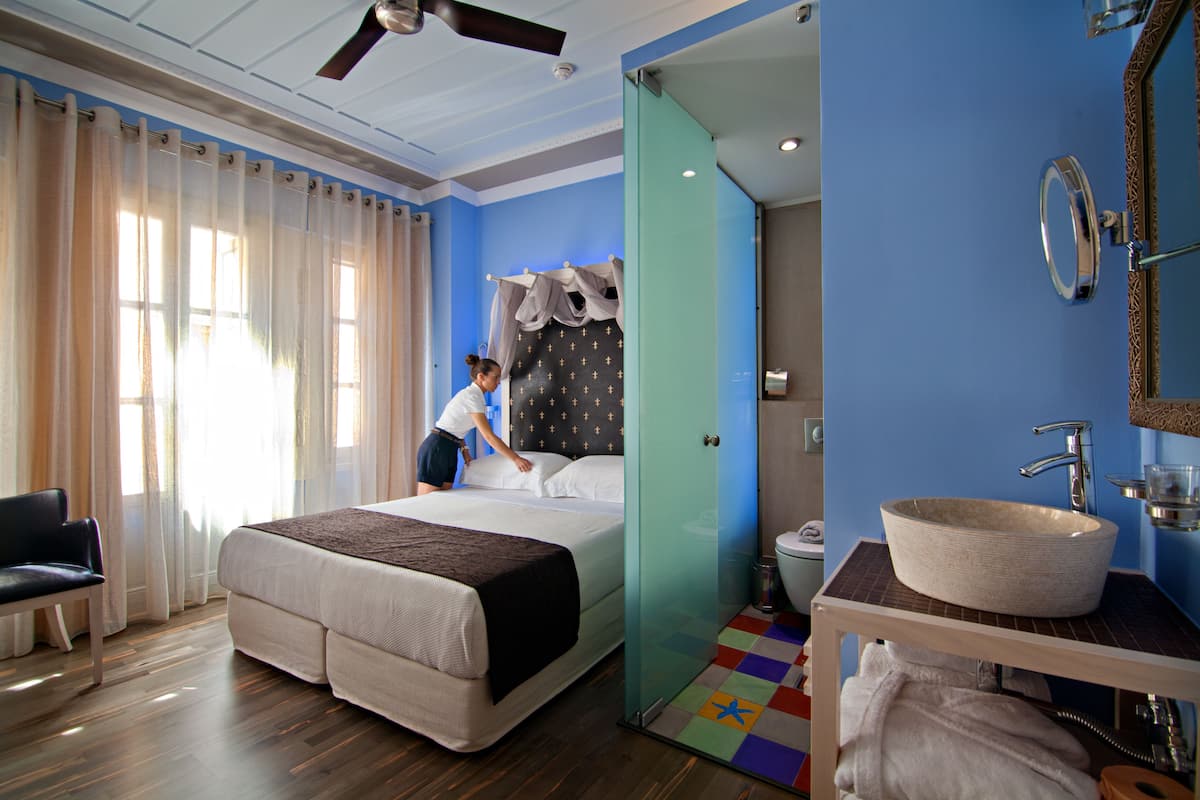 Een hotelkamer met een bed, een badkamer met een wastafel en een stoel.