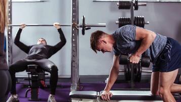 A gym with weightlifting equipment, including a bench and a squat rack.