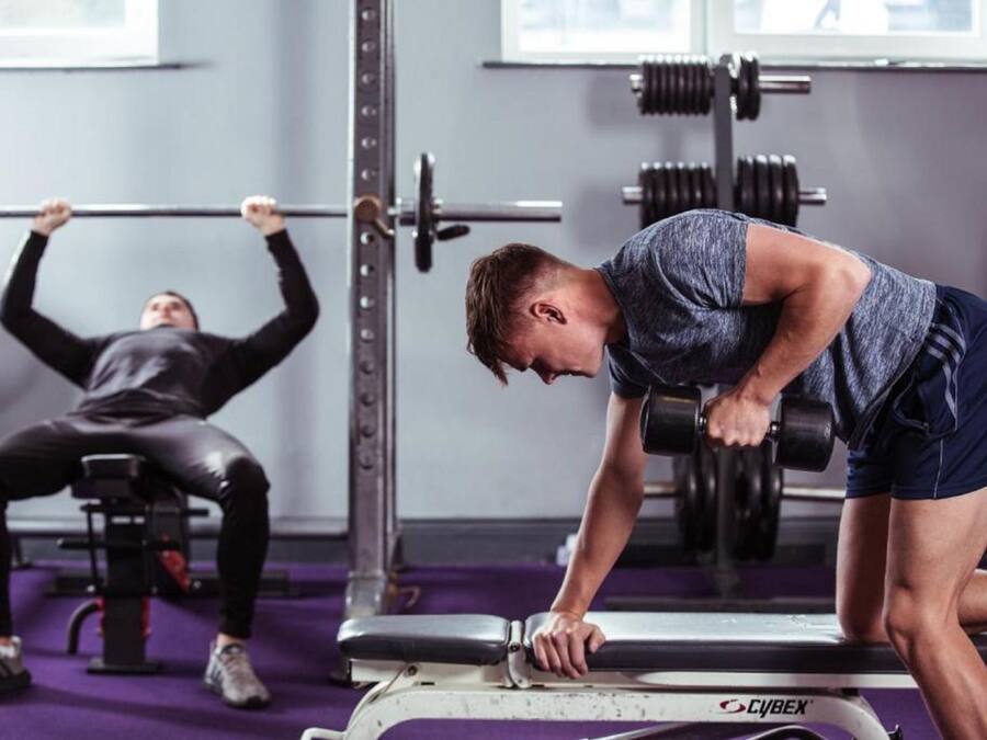 A gym with weightlifting equipment, including a bench and a squat rack.