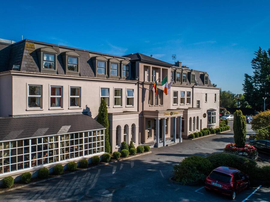A hotel with a large glass facade, multiple windows, and a flag.