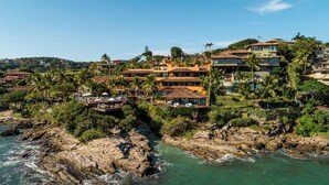 A coastal property with multiple buildings, including a large house with a balcony overlooking the sea. - Hotel Ferradura Private (Búzios)