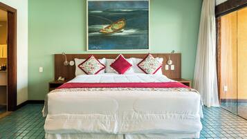 A hotel room with a large bed, a painting of a boat on the wall, and a view of the ocean through the window.