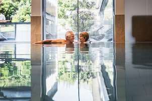 Una piscina cubierta, una piscina al aire libre, tumbonas