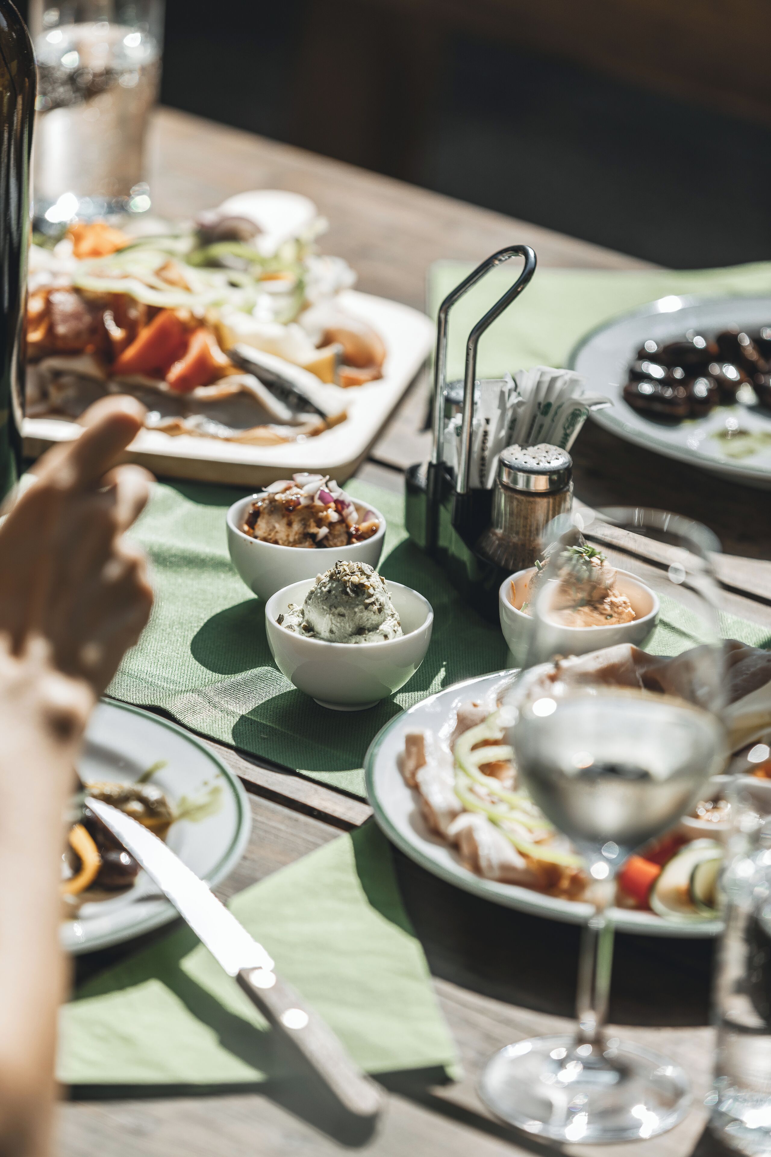 A dining table with various dishes, including bowls of food and a wine glass.