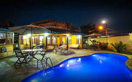 Una piscina al aire libre, sombrillas, sillones reclinables de piscina