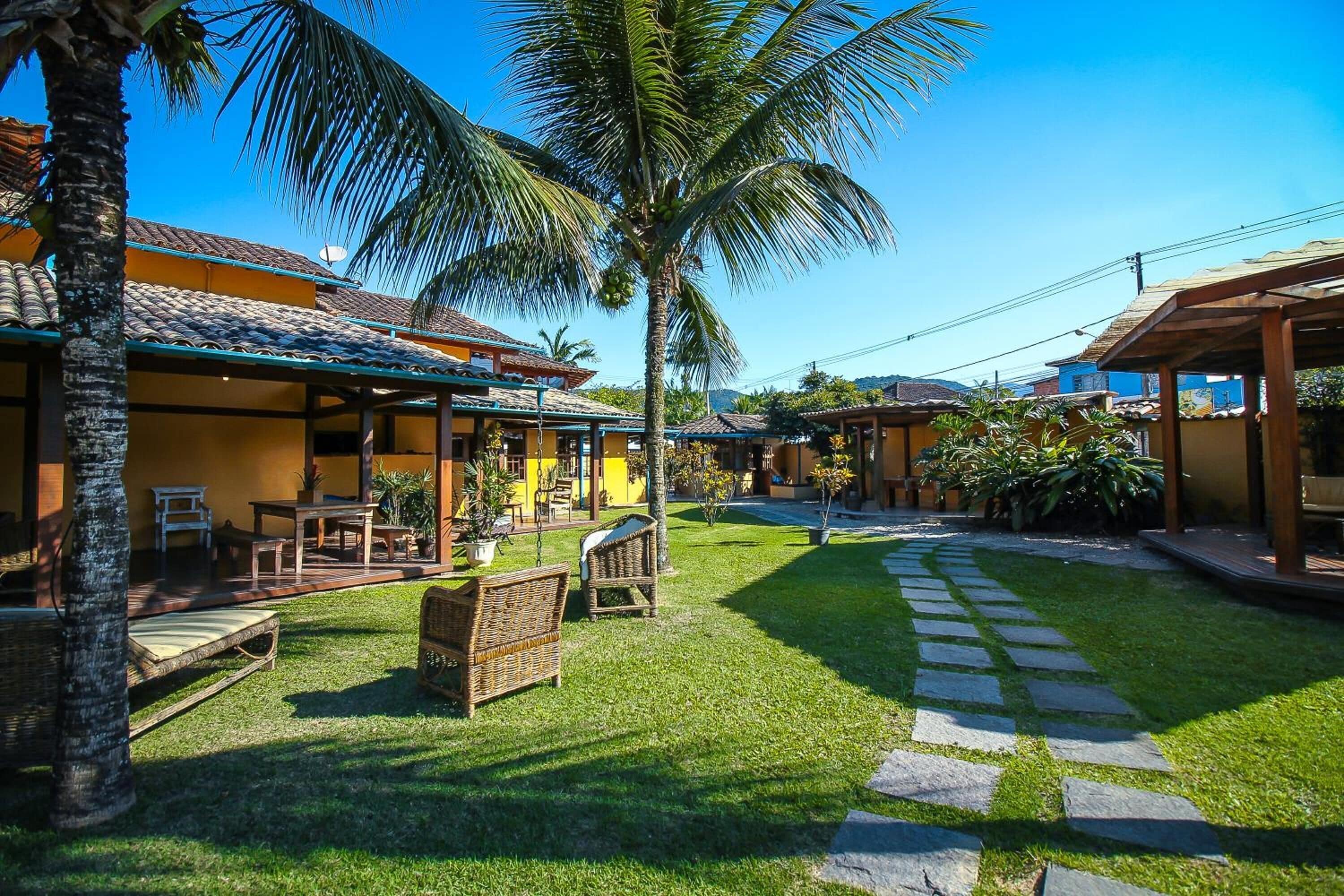 A courtyard with a palm tree, outdoor seating, and a stone pathway.