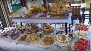 Ett buffébord med olika sorters mat, inklusive frukt, bakverk och desserter.