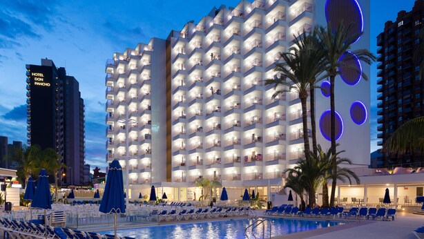 A hotel with multiple floors, a swimming pool, and outdoor seating areas. - Hotel Ambassador Playa II (Benidorm)