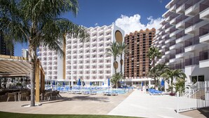 A hotel with a pool area, palm trees, and multiple buildings with balconies. - Hotel Ambassador Playa II (Benidorm)