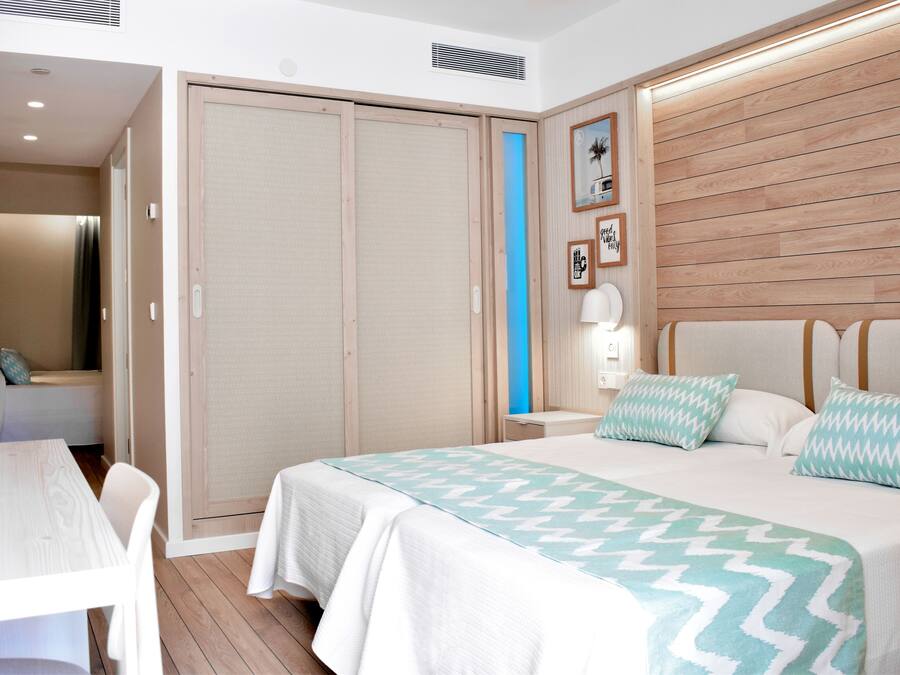 Una habitación de hotel con cama, mesita de noche y armario.