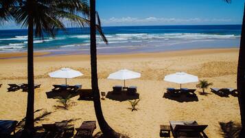 On the beach, white sand, sun-loungers, beach umbrellas