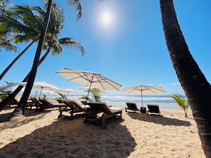 On the beach, white sand, sun loungers, beach umbrellas