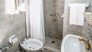 Une salle de bain équipée d’une douche, de toilettes, d’un bidet et d’un lavabo.