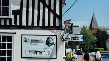 A traditional country pub with a sign advertising free beer and a 'Give Way' traffic sign.