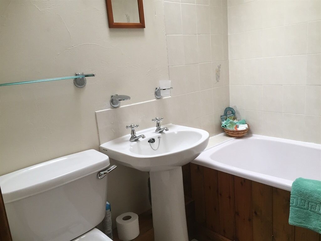 A bathroom with a toilet, sink, and bathtub.
