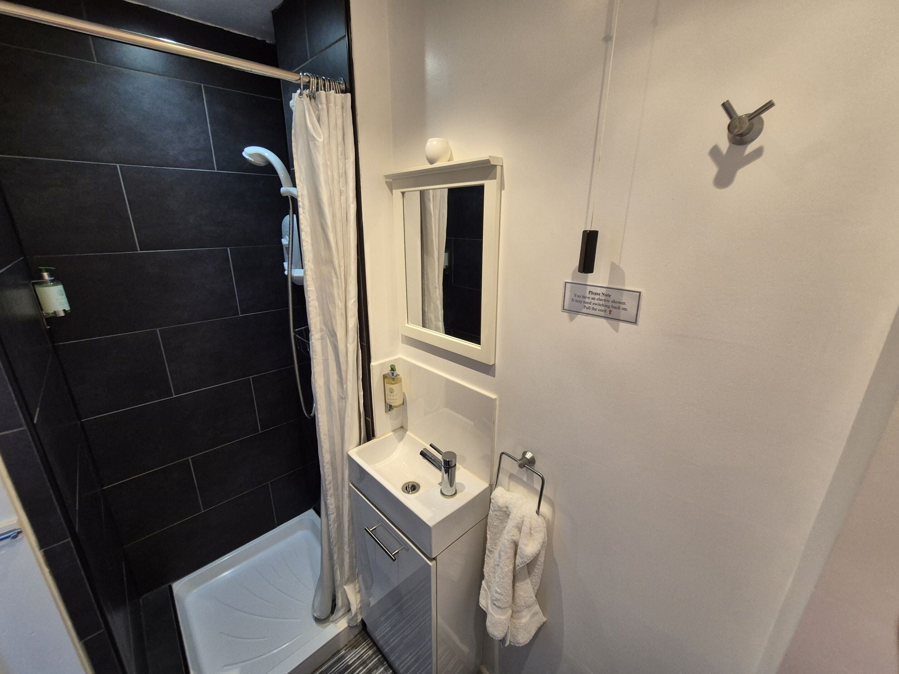 Un baño con bañera, ducha, lavabo y espejo.