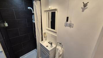 Un baño con bañera, ducha, lavabo y espejo.