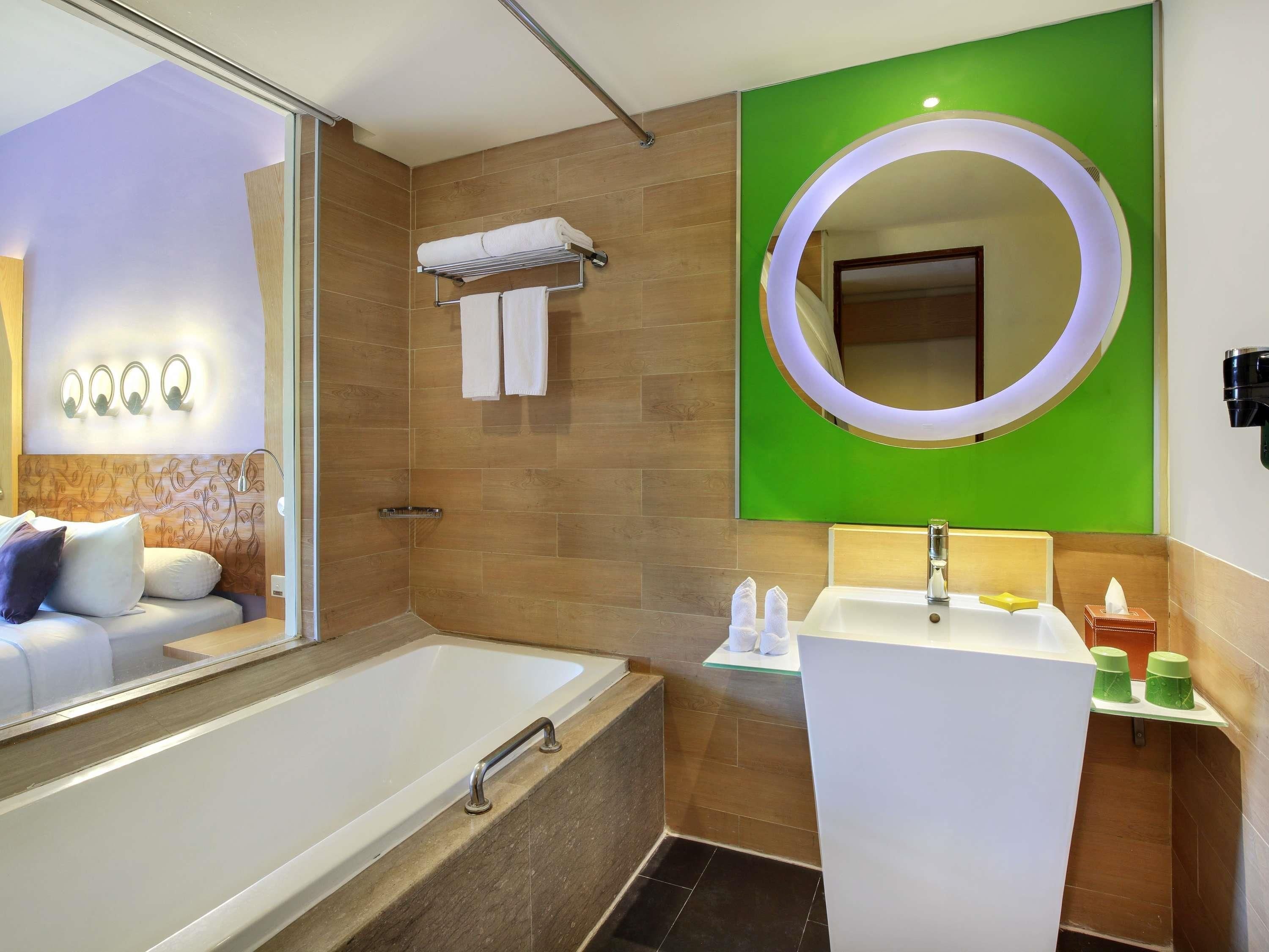 A modern bathroom with a bathtub, a sink, and a large mirror.