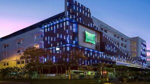 Een modern hotel met een opvallend bord van 'ibis Styles Hotels', met een eigentijds ontwerp en verticale lichtaccenten.
