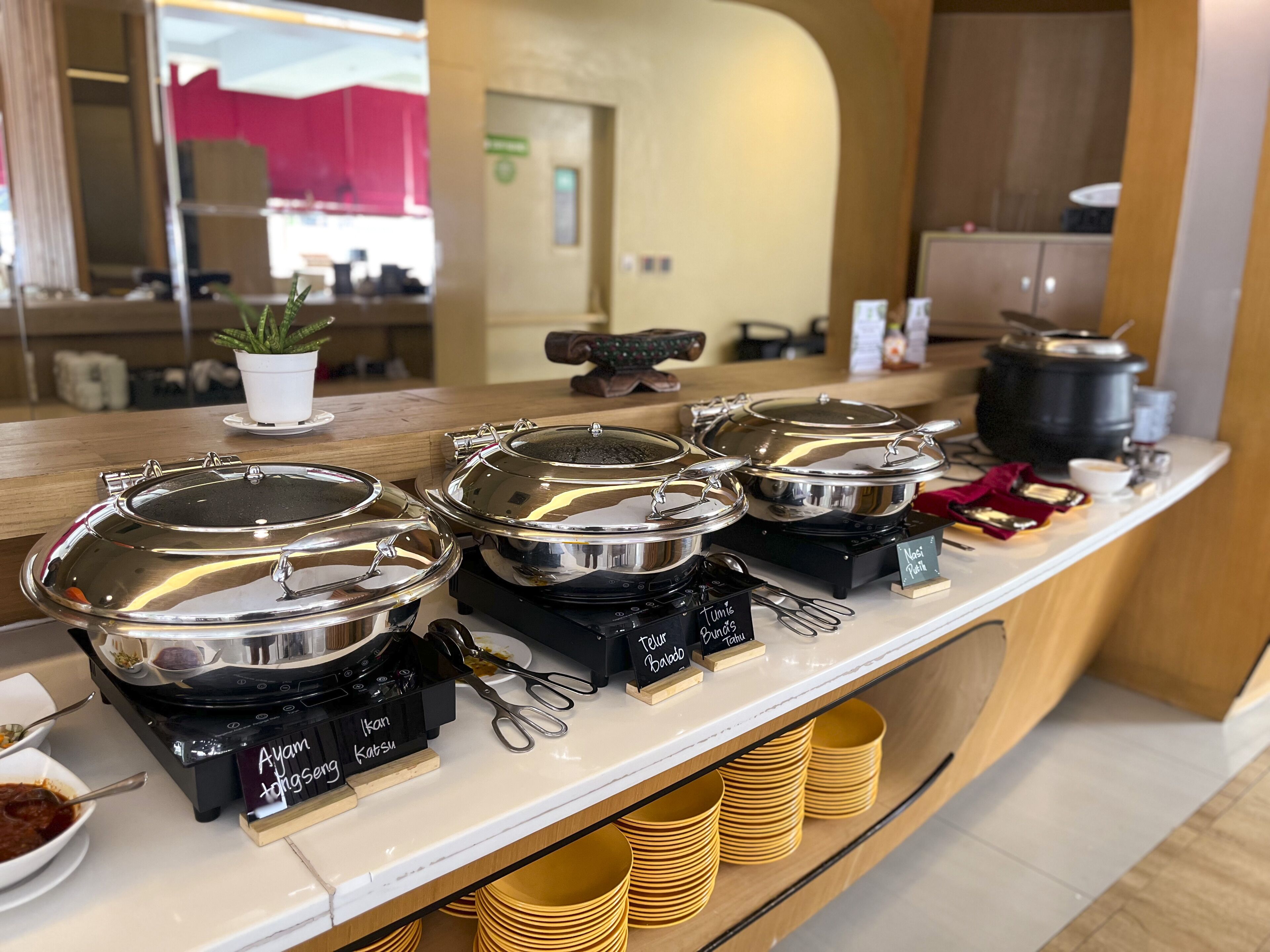 A buffet counter with multiple food stations, including a hot pot and a variety of dishes.