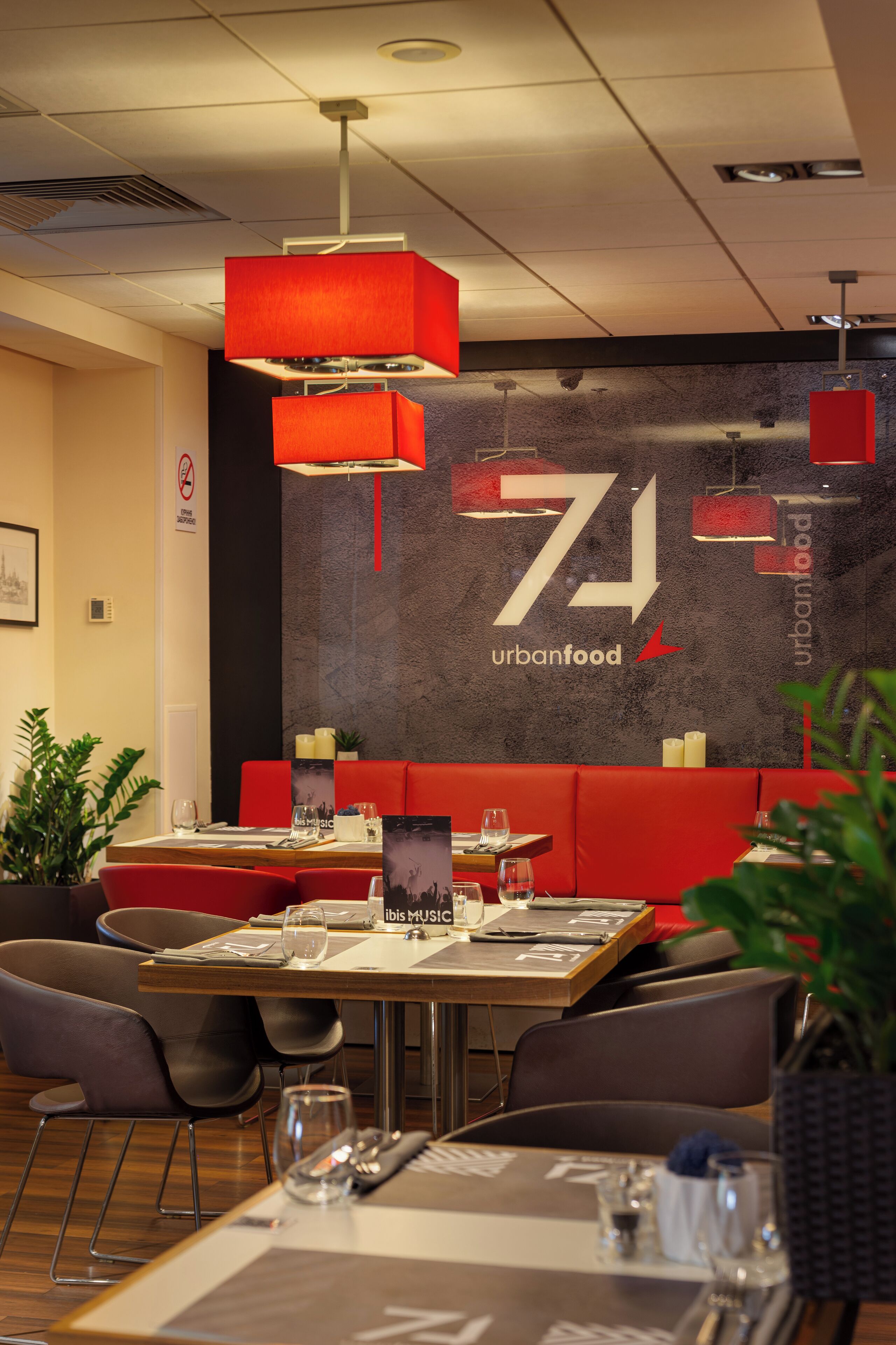 A restaurant interior with a modern design, featuring red seating, a large wall with the number 71, and a menu stand.