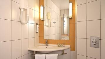 A bathroom with a sink, mirror, towel rack, and a hand dryer.