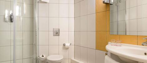 A modern bathroom with a glass-enclosed shower, a toilet, a bathtub, and a sink with a mirror.