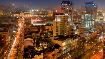 A cityscape at night with illuminated buildings, including a hotel with a prominent sign.