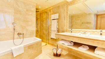 Un baño moderno con bañera, ducha y un espejo grande.