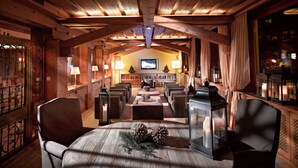 Un área de estar acogedora con paneles de madera, chimenea, asientos cómodos y televisor.