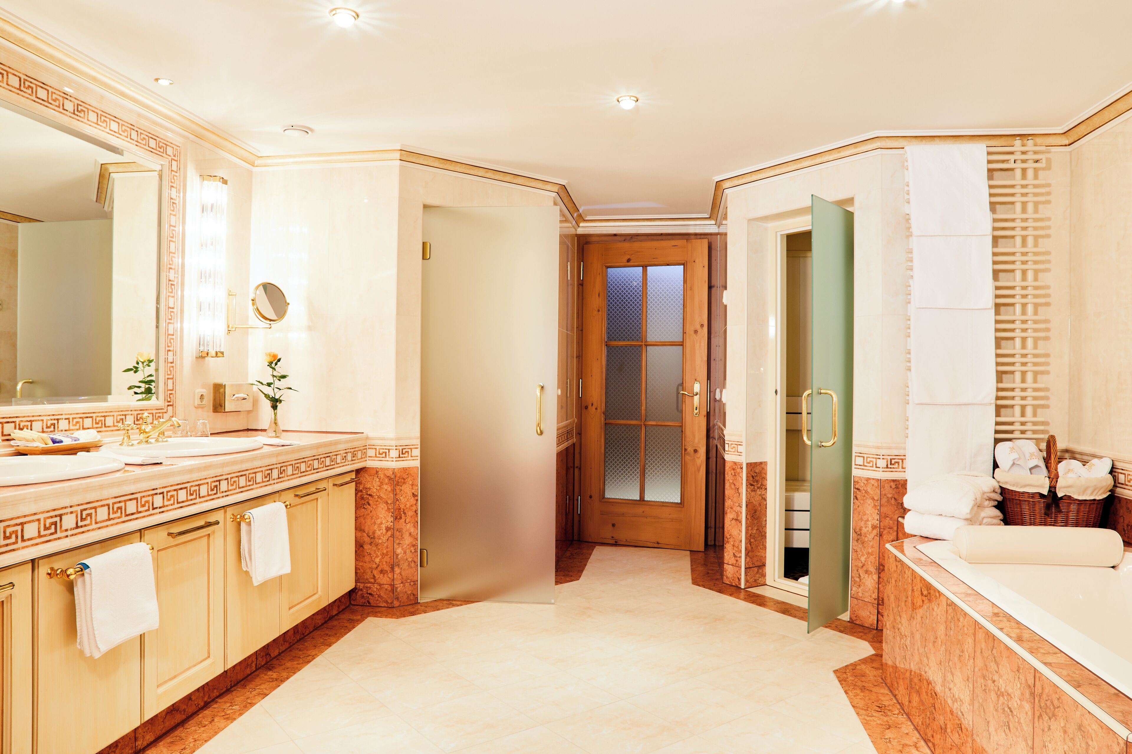 Un baño amplio con un espejo grande, una bañera y un tocador con lavamanos.