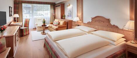 Une chambre d’hôtel avec un grand lit, un bureau avec une chaise, un canapé et un téléviseur.