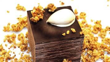 A dessert with a chocolate base, a white topping, and caramelized nuts.