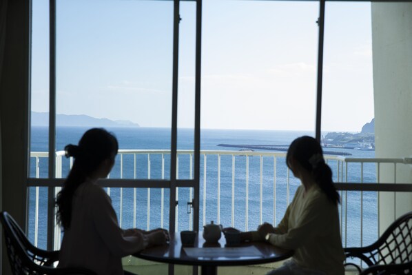 Un balcón con vista al mar y la costa lejana.