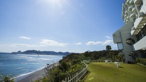 A coastal hotel with a sea view, a grassy lawn, and a modern building with balconies. - Ibusuki Royal Hotel (Ibusuki)