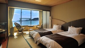 A hotel room with two beds, a TV, and a view of the sea. - Ibusuki Royal Hotel (Ibusuki)