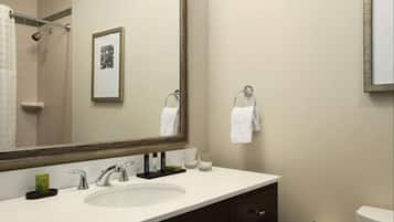 Une salle de bain moderne avec un grand miroir, un lavabo et des toilettes.