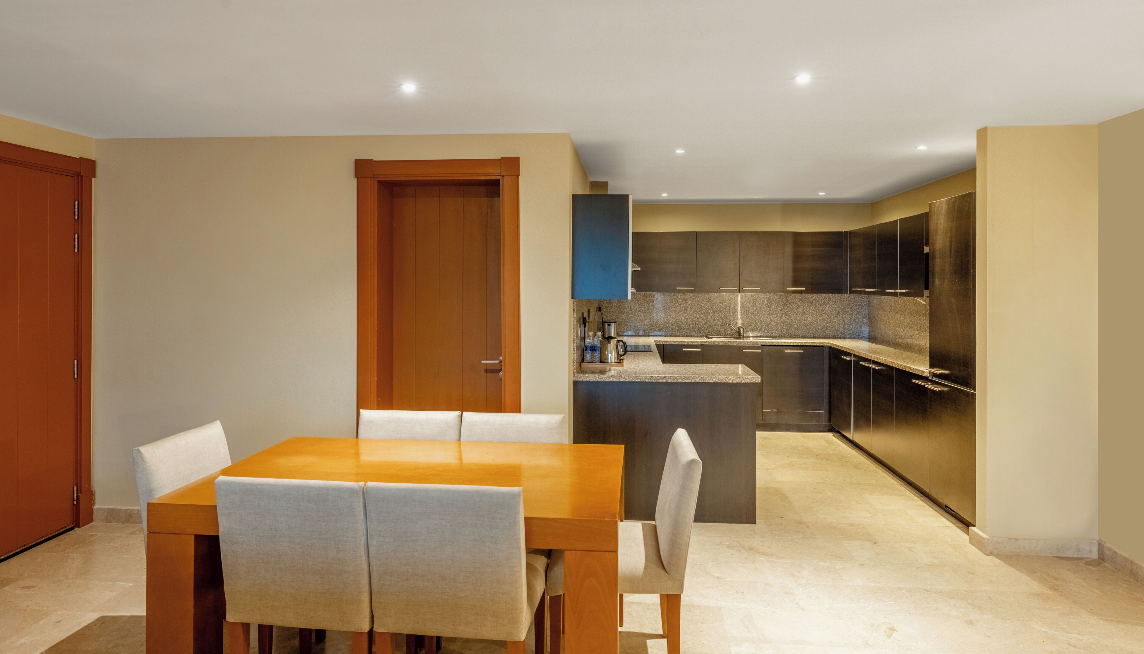 A modern kitchen with dark cabinets, a granite countertop, and a built-in oven.