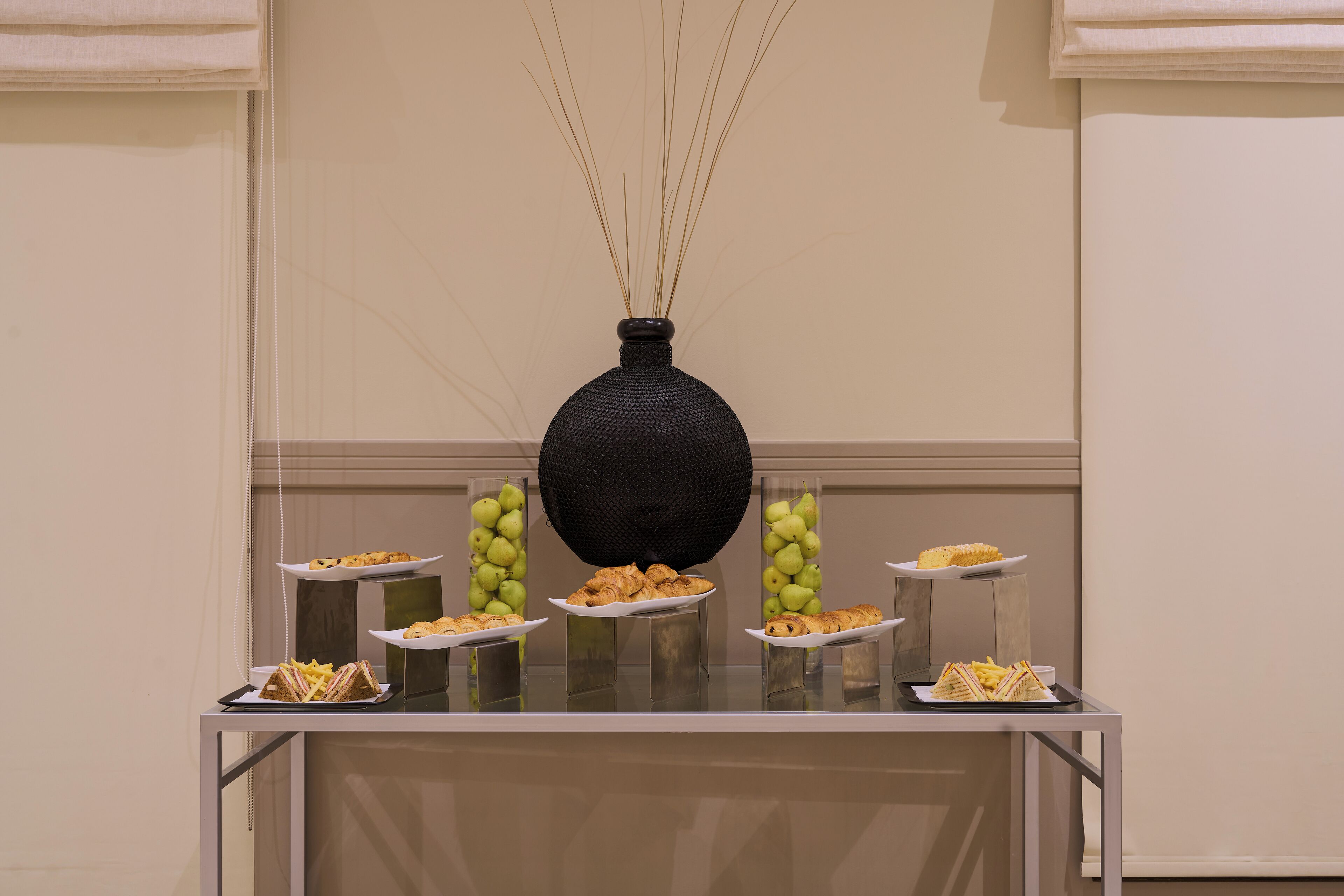 Une table de buffet garnie de divers plats et agrémentée d’un vase décoratif.